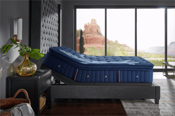 A Stearns and Foster Lux Estate Marcela mattress flexing perfectly while elevated on an adjustable power base in a modern bedroom setting.