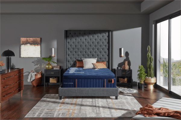 Elegant master bedroom featuring a Stearns and Foster Lux Estate Marcela mattress on a modern frame with large windows overlooking a scenic desert background.